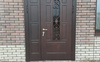 дверь двустворчатая стальная для загородного дома с ковкой и стеклом